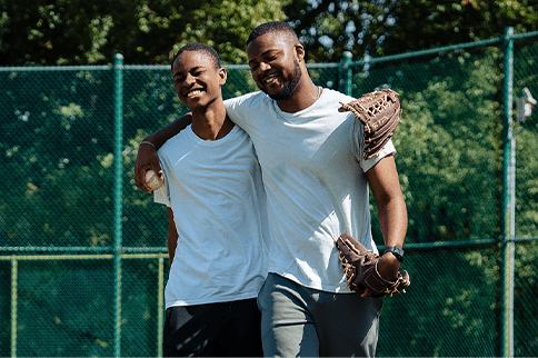 Austin smiling in baseball gloves with his brother Austin smiling in baseball gloves and arms around his brother